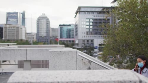 Woman Walks City Stairs, Talking on Phone, Wearing Mask