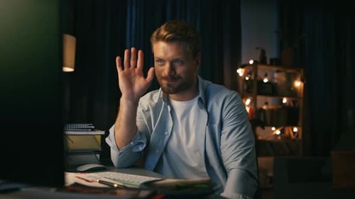 Man Using Computer at Desk at Night