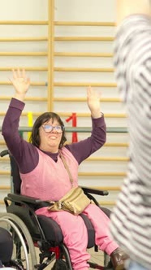 Adults Stretch with Arms Raised in a Gym