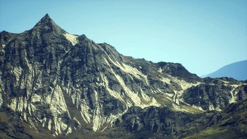 Majestic Mountain Peak with Rugged Terrain Under Clear Blue Sky at Midday