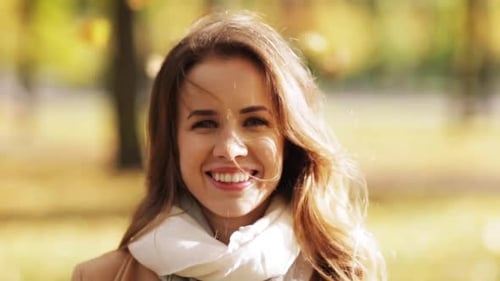 Beautiful young woman smiling happily in autumn park fashion lifestyle season