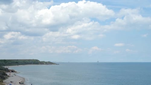 Breathtaking Time Lapse View on Coastline with Clouds Passing and Ship Silhouette on Horizon