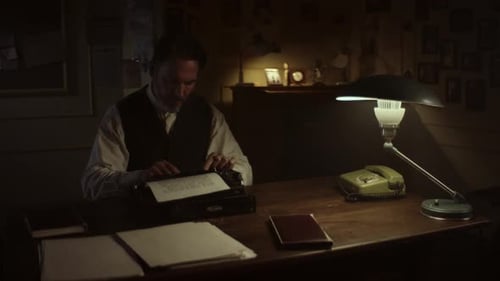 Writer working late at night on typewriter in his office