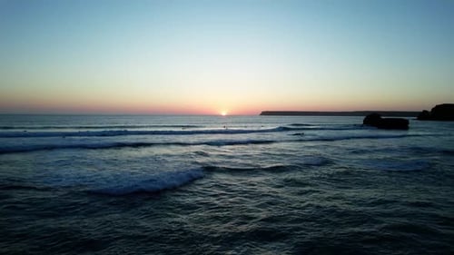 Surfing And Swimming In The Ocean During Sunset. - aerial shot