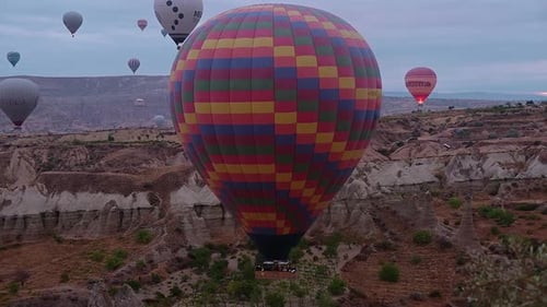 Hot Air Balloons Floating Over Rugged Cappadocia Landscape