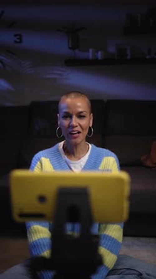 Smiling Woman Waves at Smartphone Video at Night