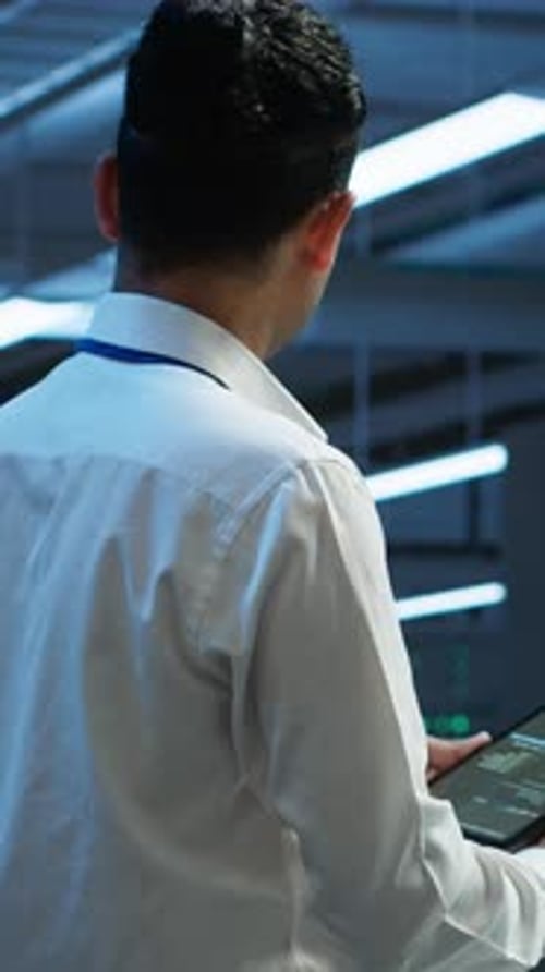 Young Male IT Professional Using a Tablet in a Server Room