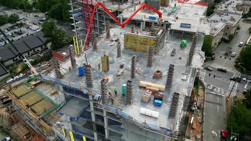 High angle view of casting concrete load structures on multistorey building construction site. Peopl