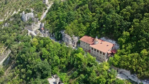 Beautiful buildings in the mountains. Stone architecture on the hill among green nature in summer.