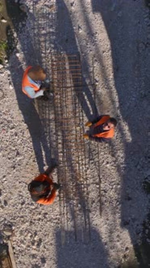 Vertical Video Busy Construction Site Aerial View Showcasing Active Workers and Machinery on a New
