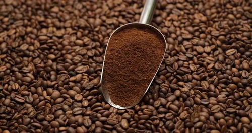 Cuchara metálica llena sobre un café molido sobre un fondo giratorio, imágenes de alta calidad