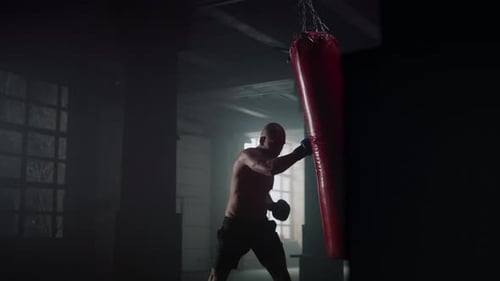 Athletic Sportsman Boxing Punch Bag at Workout in Sport Club. Mixed Race