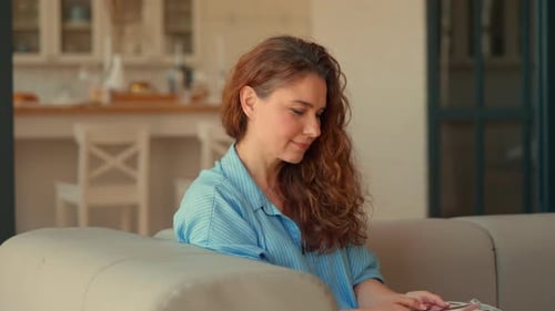 Woman Relaxing at Home Using Smartphone