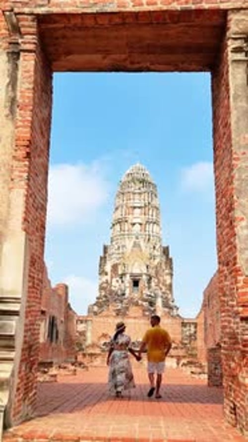 Couple Walks Under Brick Arch Towards Medieval Temple a Sacred Site Ayutthaya Thailand