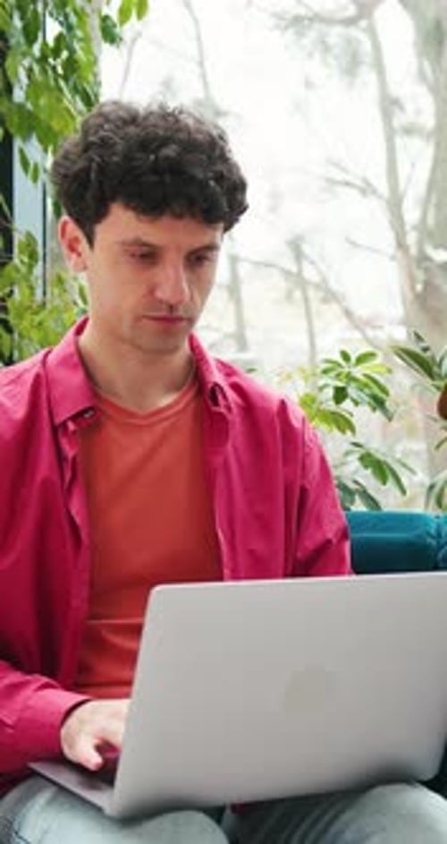 Man Using Laptop in a Bright Indoor Setting
