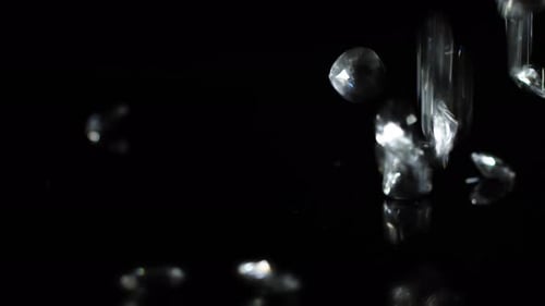 Diamond raining on a black shiny surface to indicate luxury or wealth or as a gift for special occat