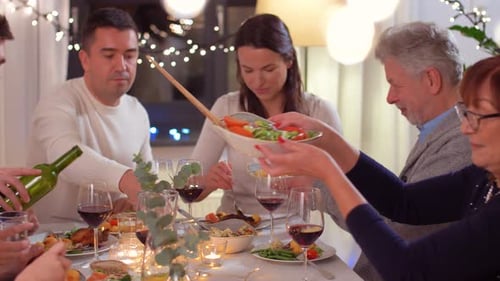 Family Sharing Food Around Dining Table At Home