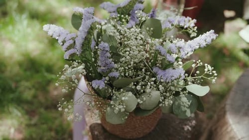 delicate spring bouquet in rustic pot on sunlit outdoor setting