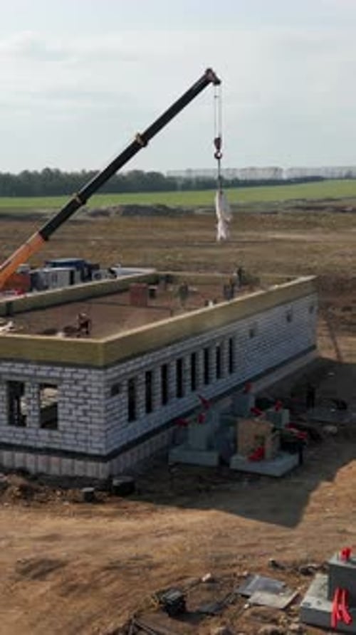 Construction Crane Lifting Materials at Building Site Clip