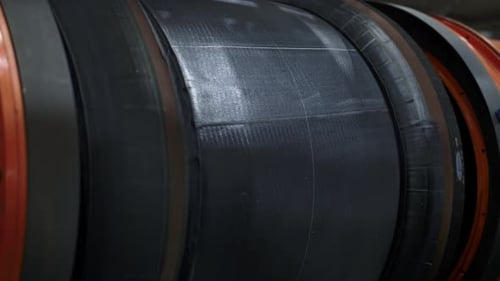 Tyre manufacture employee maintaining production process at modern automotive factory