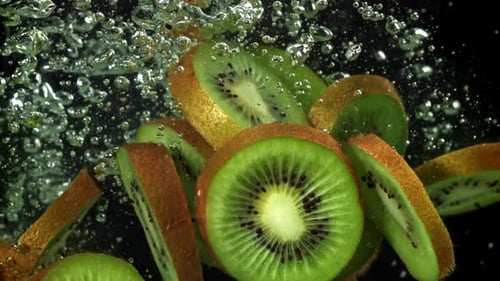 Kiwi Fruit Slices Falling into Water with Bubbles