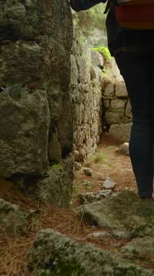 Woman Hiking Through Ancient Stone Ruins