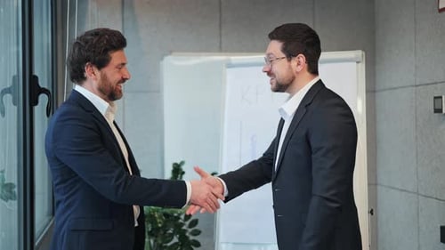 Businessmen Shake Hands in Modern Office Setting