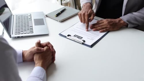 Der Bewerber reicht seinen Lebenslauf während des Vorstellungsgesprächs mit dem Unternehmensleiter ein.