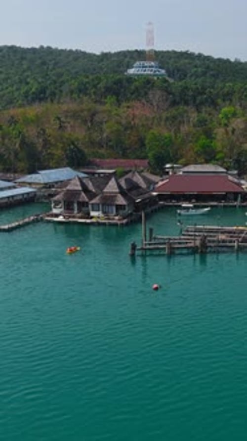 Two Guys Paddling in a Kayak Among the Houseboats of Log Chang Island