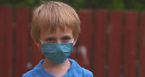 Portrait of a little boy wearing a face mask to protect against covid-19 coronavirus.