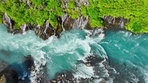 Fluss mit klarem Gletscherwasser, Bergwasserfall, umgeben von dichten grünen Bäumen und Büschen