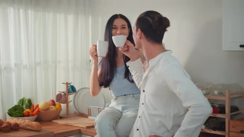 Couple Chatting and Drinking Coffee Together in Kitchen