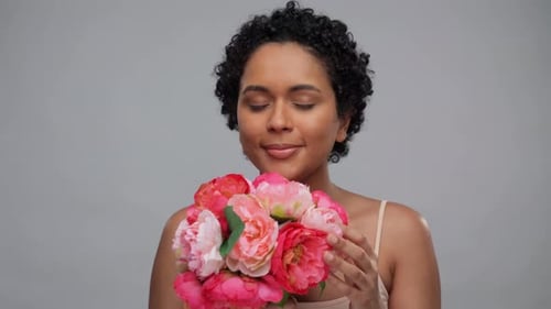 Woman Smelling and Admiring Bunch of Flowers Smiling