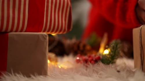 Hands Decorating Christmas Gift with Red Berries