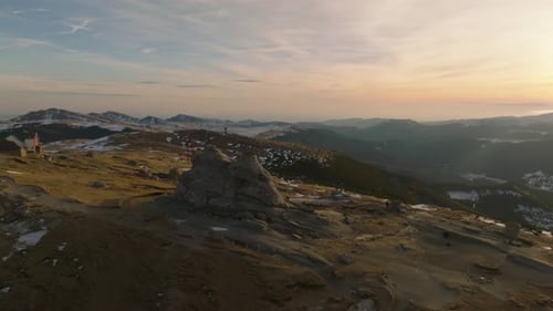 Film filmé en orbite aérienne d'un sphinx de Bucegi roumain avec des touristes à côté dans les Carpates