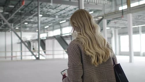 Female Inspector Walking in Empty Warehouse Adult