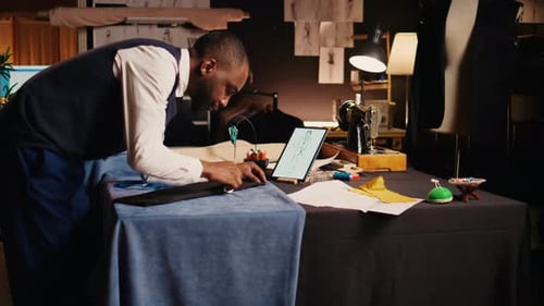 Tailor Working on Garment With Tablet Sketch