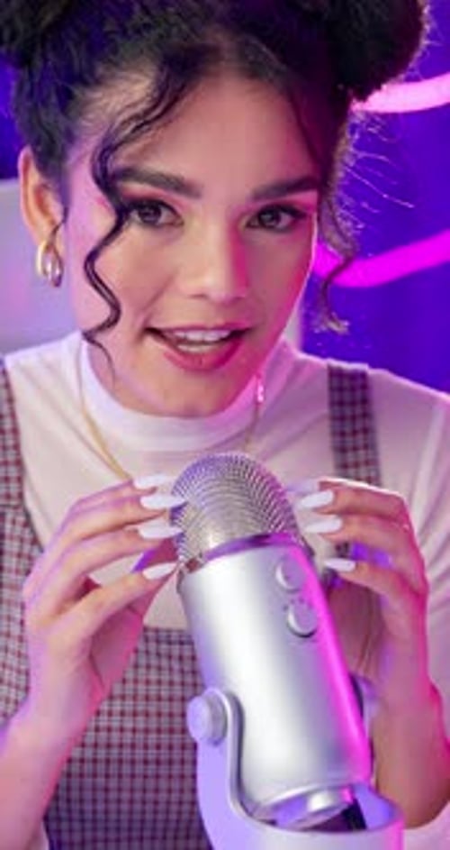 Podcast, woman and happy with hands on microphone with neon background for live streaming