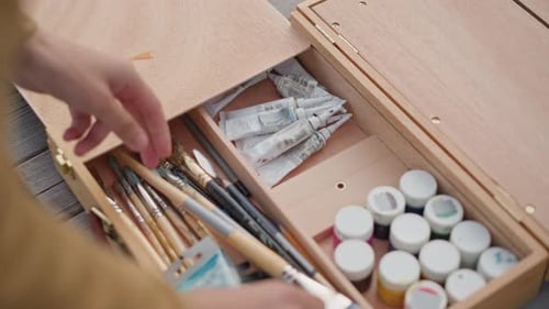 Préparation de fournitures artistiques sur la terrasse Vue rapprochée de l'artiste manipulant des Pinceaux et mélangeant les couleurs Artiste