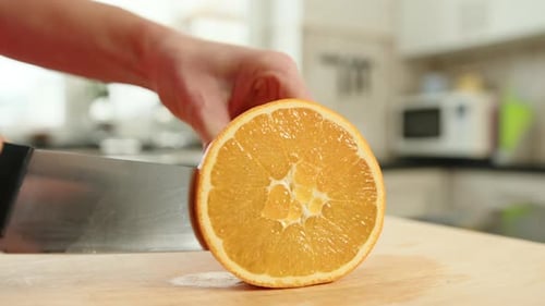 Orange Being Sliced in Kitchen Close Up