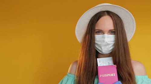 Young Woman Wearing Mask Holding Passport and Ticket