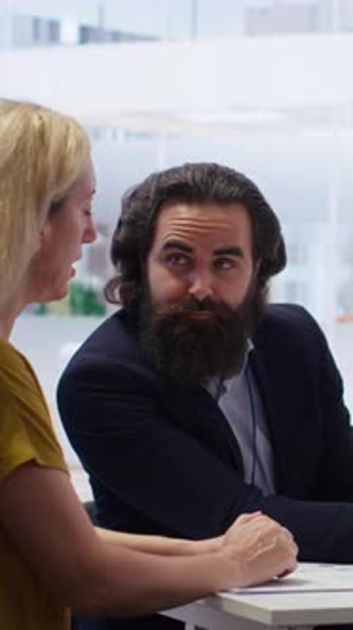 Vertical Video Financial Advisor and Clients Looking at Market Shares on Tablet