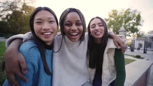 Three Smiling Women Hugging in an Urban Park