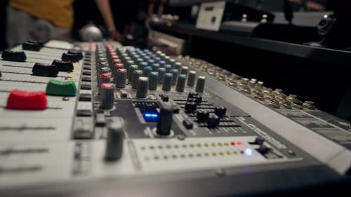 close-up shot of the male hand of a sound engineer switching settings on mixing console