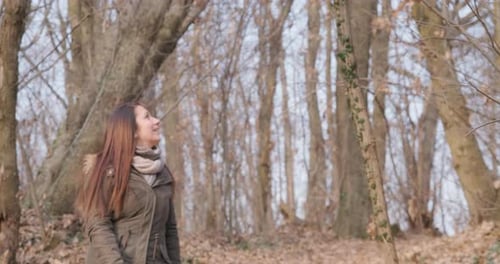 Brunette Woman Wearing Winter Jacket Walking In Forest And Looking Around On A Sunny Day. - slow mot