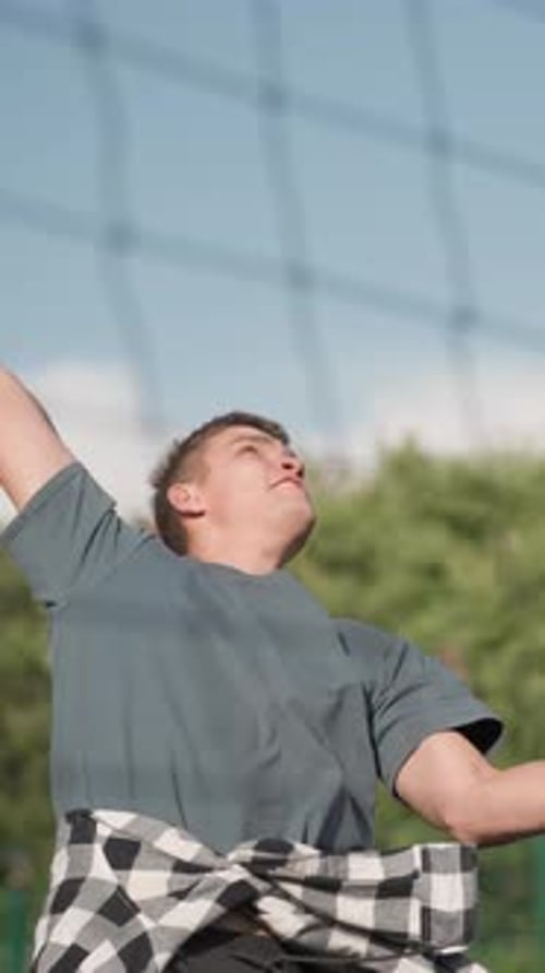 Young Man Playing Volleyball Outside on Sunny Day