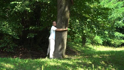 Man hug a tree in the forest. Spiritual connection, energies, joy and life concepts.