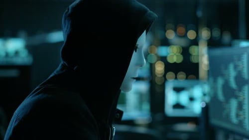 Masked Hacker Working at Night on Computers