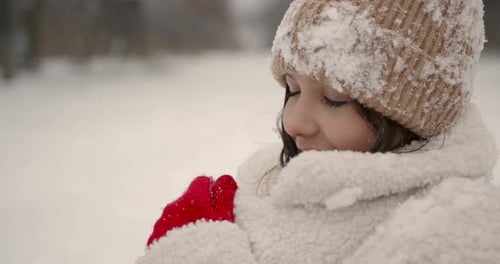 Beautiful Girl in Snowflakes Getting Warm in Winter Forest