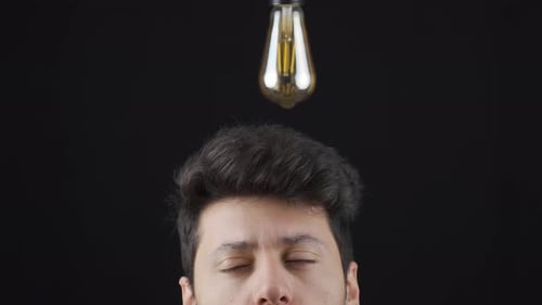 Über dem Kopf des Mannes, der eine Idee hat, leuchtet eine Lampe auf. Um Ideen zu generieren.